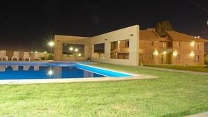 A modern building with a swimming pool and lounge chairs. - Aire Andino Apart Hotel (San Juan)