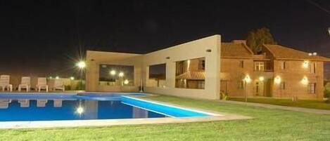 Un bâtiment moderne doté d’une piscine et de chaises longues.