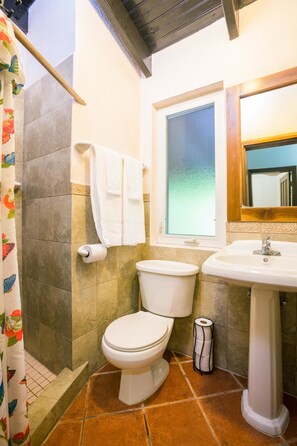 A bathroom with a toilet, sink, and shower curtain.