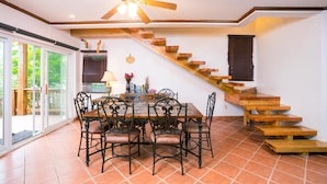 A dining area with a wooden staircase and a ceiling fan. - Bayside Villa 3A (Roatan)