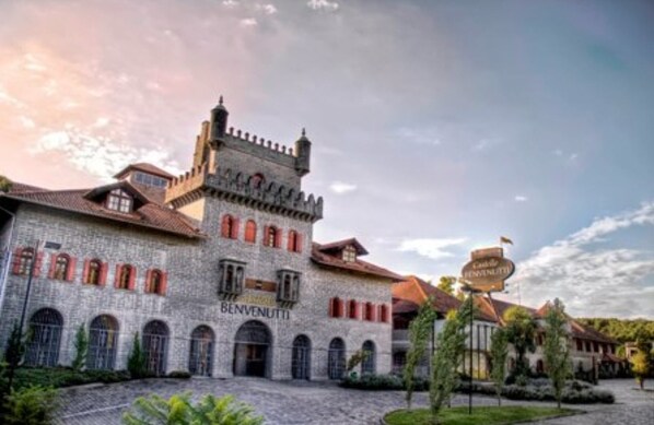 A historic building with a stone facade, arched windows, and a tower. The name "BENVENUTTI" is visible on the building. - Pousada Castello Benvenutti (Garibaldi)