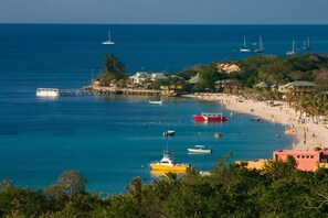 A coastal town with a beach, boats, and a pier.