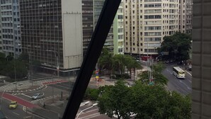 Une vue sur un paysage urbain, prise à travers une fenêtre dont le cadre est en métal.