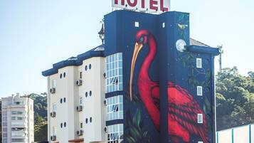 Un edificio de hotel con un gran mural de un pájaro rojo en su fachada.