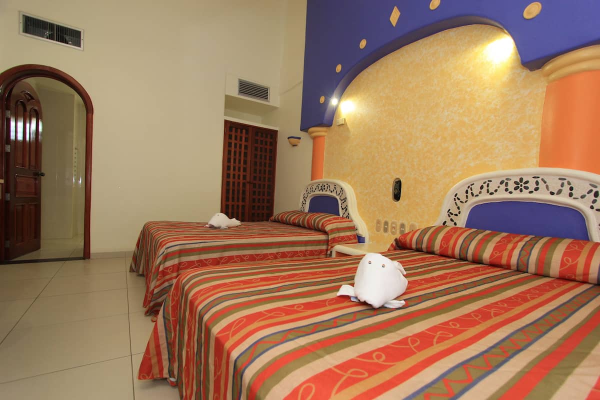 Une chambre d’hôtel avec deux lits, chacun étant agrémenté de draps à rayures et d’un jouet en peluche blanc posé sur l’un des lits. On y trouve une porte et une fenêtre avec un volet en bois.