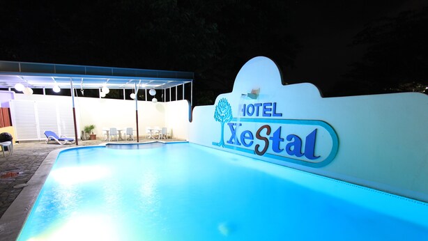 A swimming pool area with a sign for HOTEL XeStal. - Hotel Xestal (Santa María Huatulco)