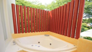 A hot tub with a yellow exterior and a red fence surrounding it. - Hotel Xestal (Santa María Huatulco)