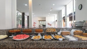 A buffet counter with various food items including cakes, pastries, and bread. - Ritz Plazamar Hotel (Maceió)