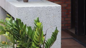 A concrete sink with a faucet and a soap dispenser against a brick wall. - Ritz Plazamar Hotel (Maceió)