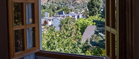 Ein Zimmer mit einem großen Bogenfenster, das Blick auf ein Dorf am Hang bietet.