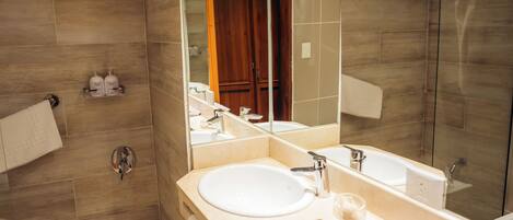 A modern bathroom with a large mirror, a sink, and a shower area.