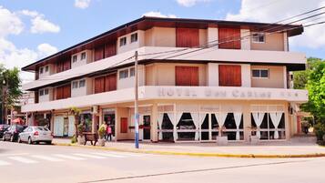 Un edificio de dos pisos con un letrero que dice 'HOTEL DON CARLOS'.