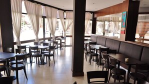 A restaurant with tables and chairs arranged for dining. - Don Carlos Hotel (Villa Gesell)