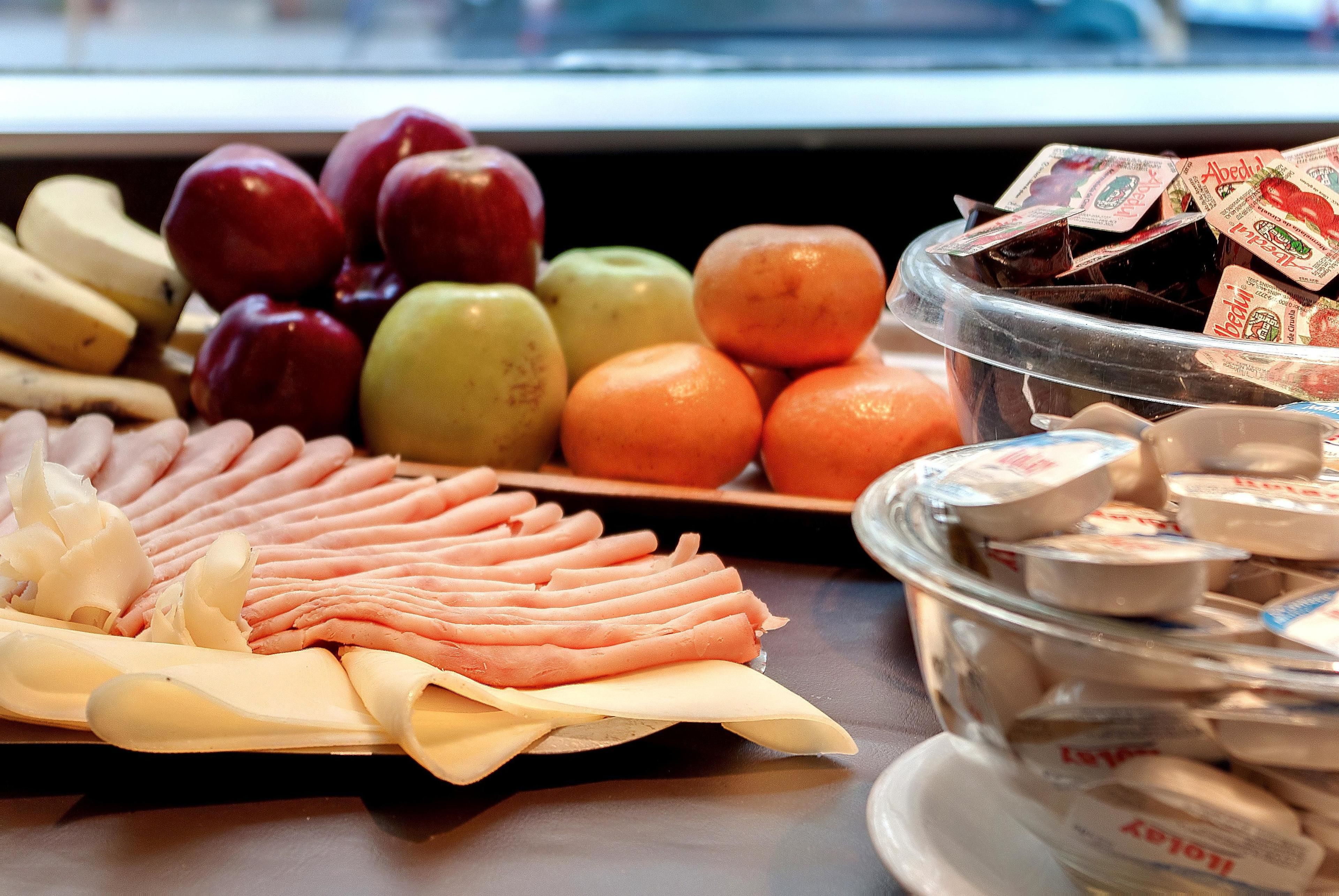 Buffet com diversas frutas, queijos e embutidos.