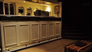 A kitchen with white cabinetry, a countertop, and a small table with a magazine. - Don Carlos Hotel (Villa Gesell)