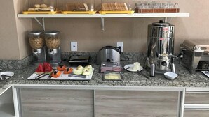 A breakfast bar with various food items and kitchen appliances. - Cerrado Hotel (Campo Grande)