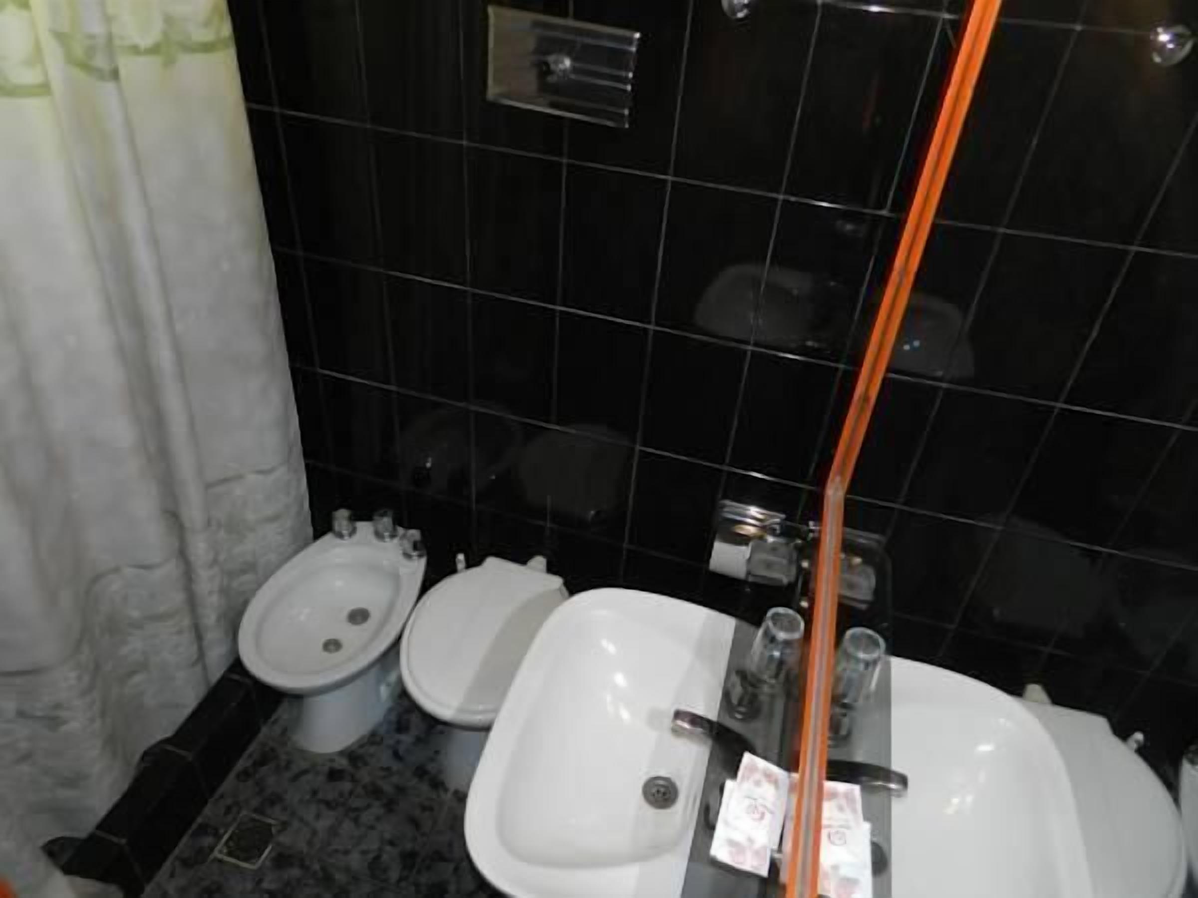 A bathroom with a bidet, a toilet, and a sink.