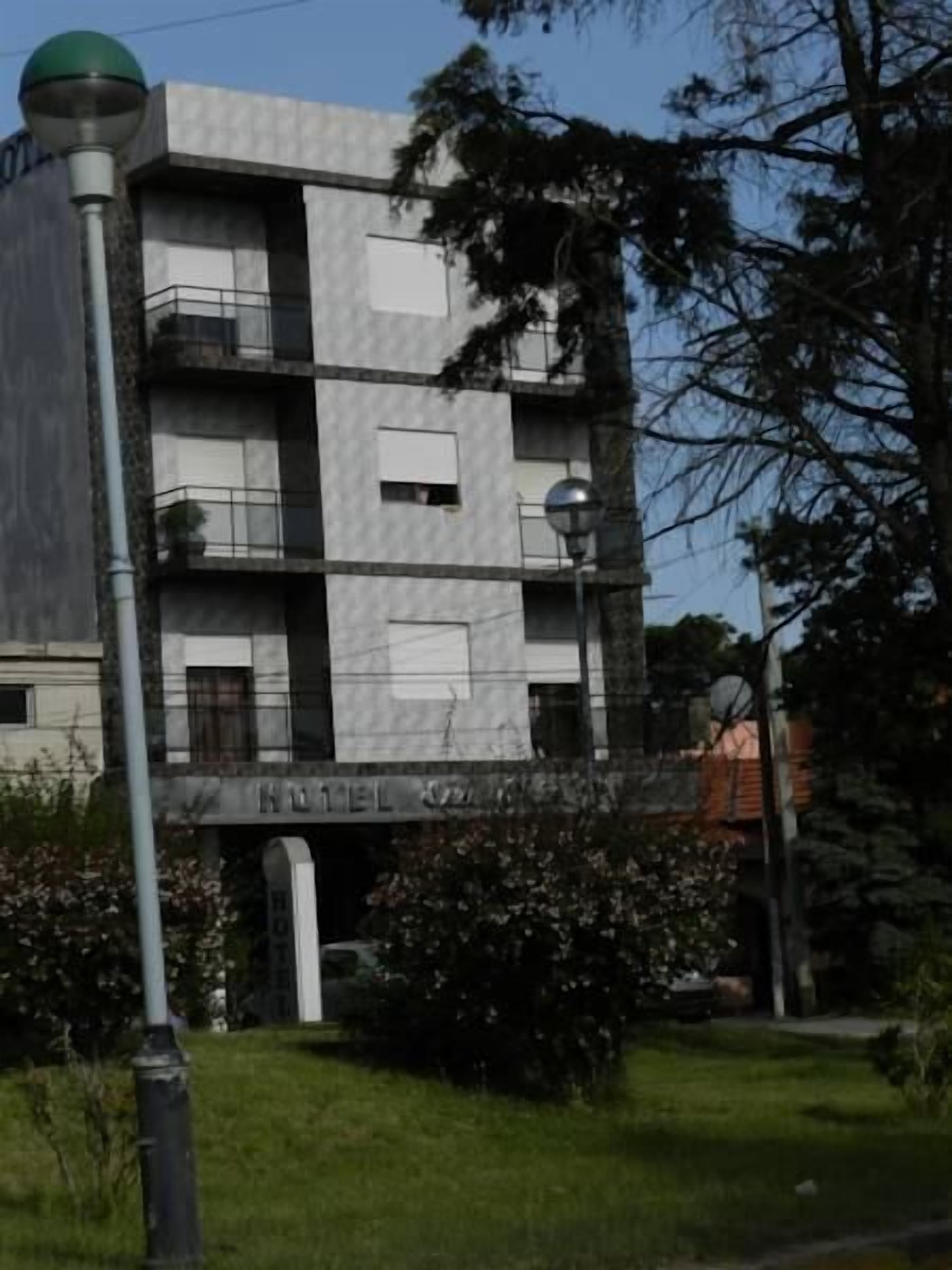 A multi-story hotel with a modern architectural design, featuring balconies and a visible entrance.