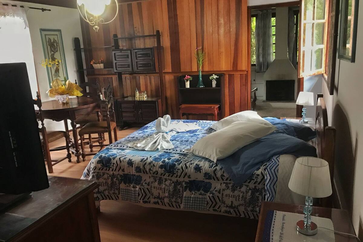 Une pièce comprenant un lit, un bureau, une chaise, une télévision et une lampe.