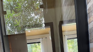 Une salle de bain moderne avec un grand miroir, un lavabo et un espace douche.