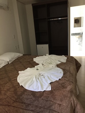 A hotel room with a bed, a wardrobe, a small desk, and a bathroom visible through an open door. - Pousada Beija Flor Centro (Gramado)