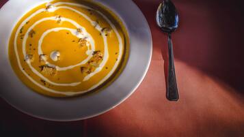 Uma tigela de sopa com uma colher sobre a mesa.