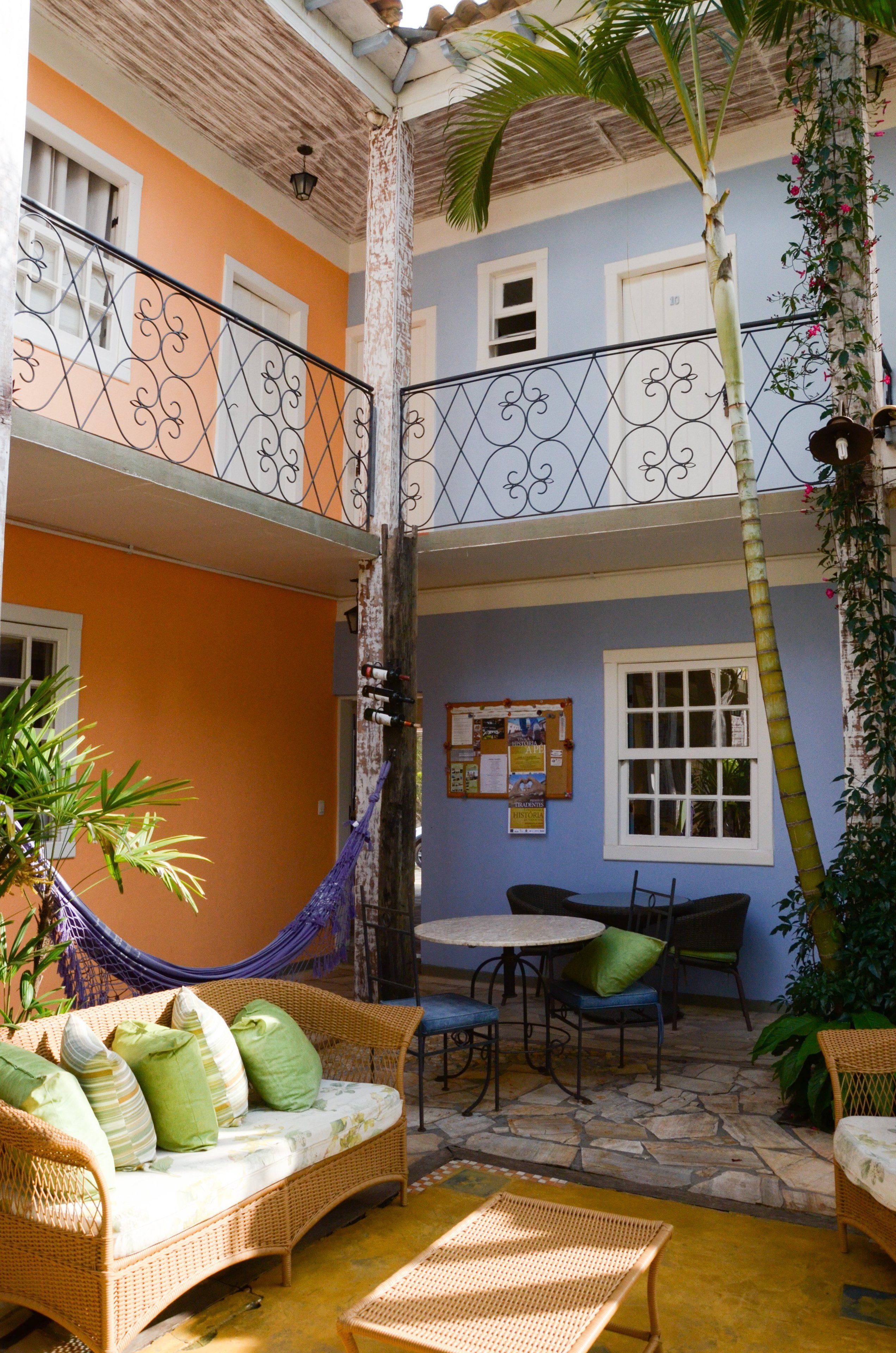 A two-story building with a balcony, outdoor seating area, and a hammock.