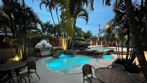 A pool area with seating and tropical plants. - Pousada Villa Alferes (Tiradentes)