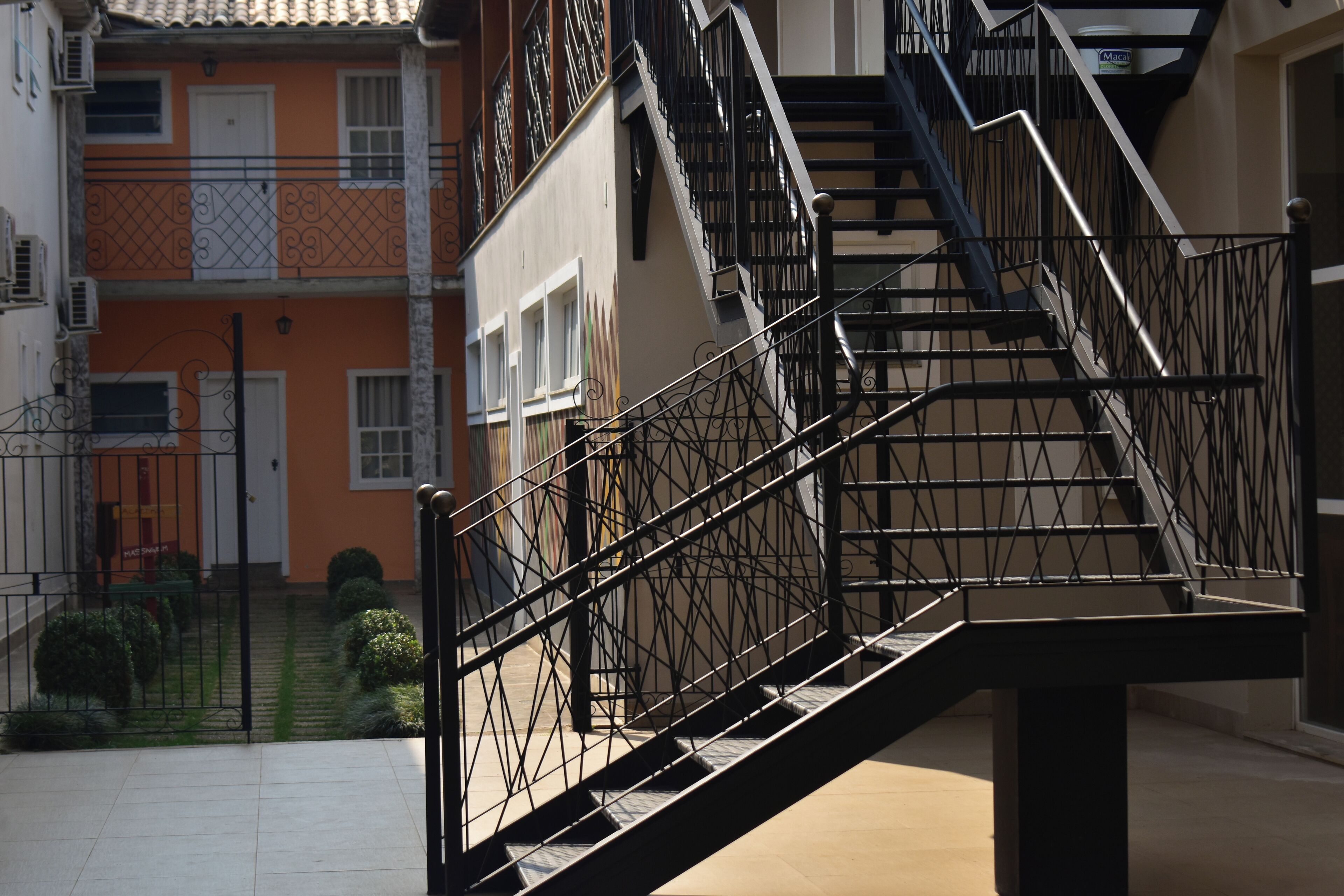 A multi-story building with a staircase and a gated entrance.