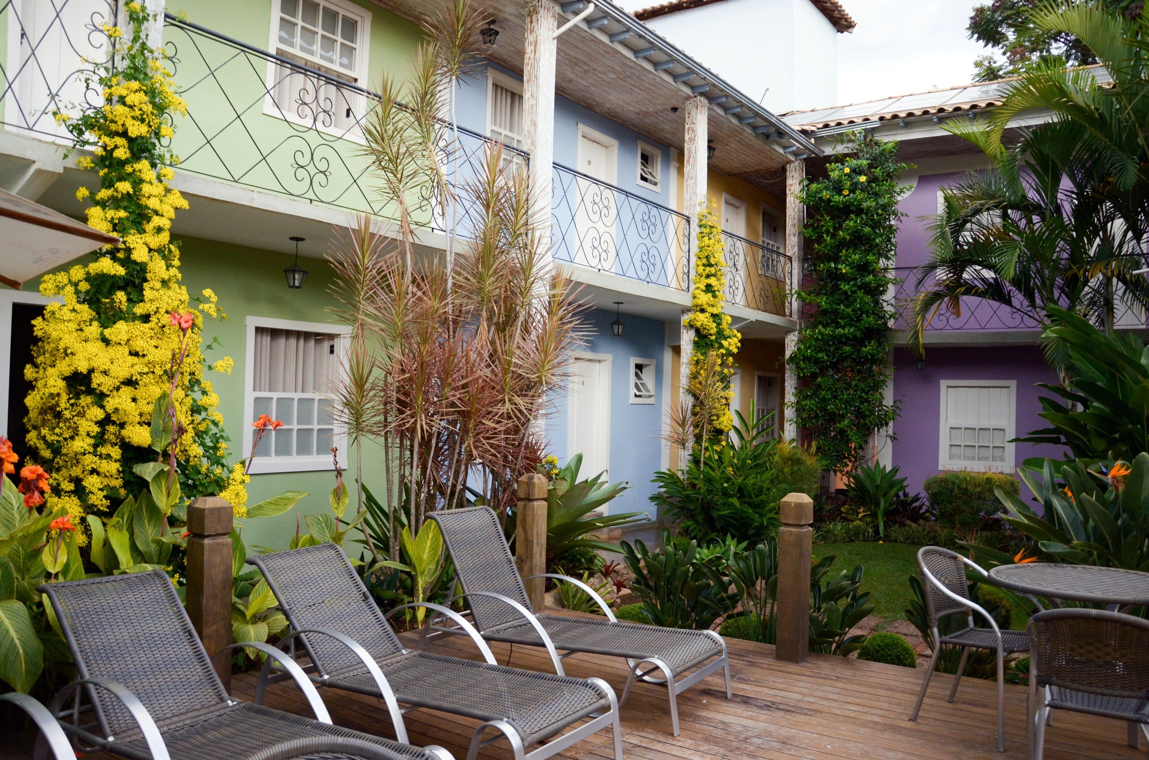 A courtyard with outdoor seating, a wooden deck, and a variety of plants and flowers.