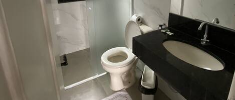 Un bagno moderno con toilette, lavandino e specchio.