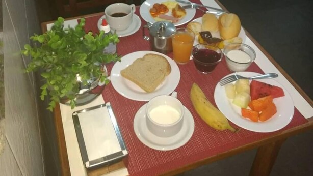 Una mesa de desayuno con tostadas, huevos, fruta y una taza de café.