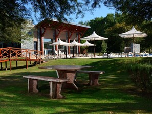 Relax in a covered seating area with a pool and lounge chairs nearby.