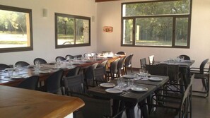 Enjoy a formal dining experience with a long table set for a meal, offering a view of the surrounding woods.