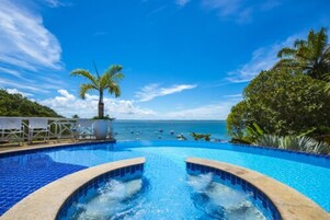 Una piscina al aire libre, sombrillas, sillones reclinables de piscina