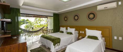 A hotel room with two beds, a desk, and a hammock outside the window.