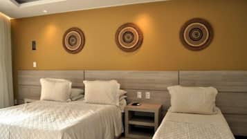 A hotel room with two beds, a wooden headboard, and decorative wall art.