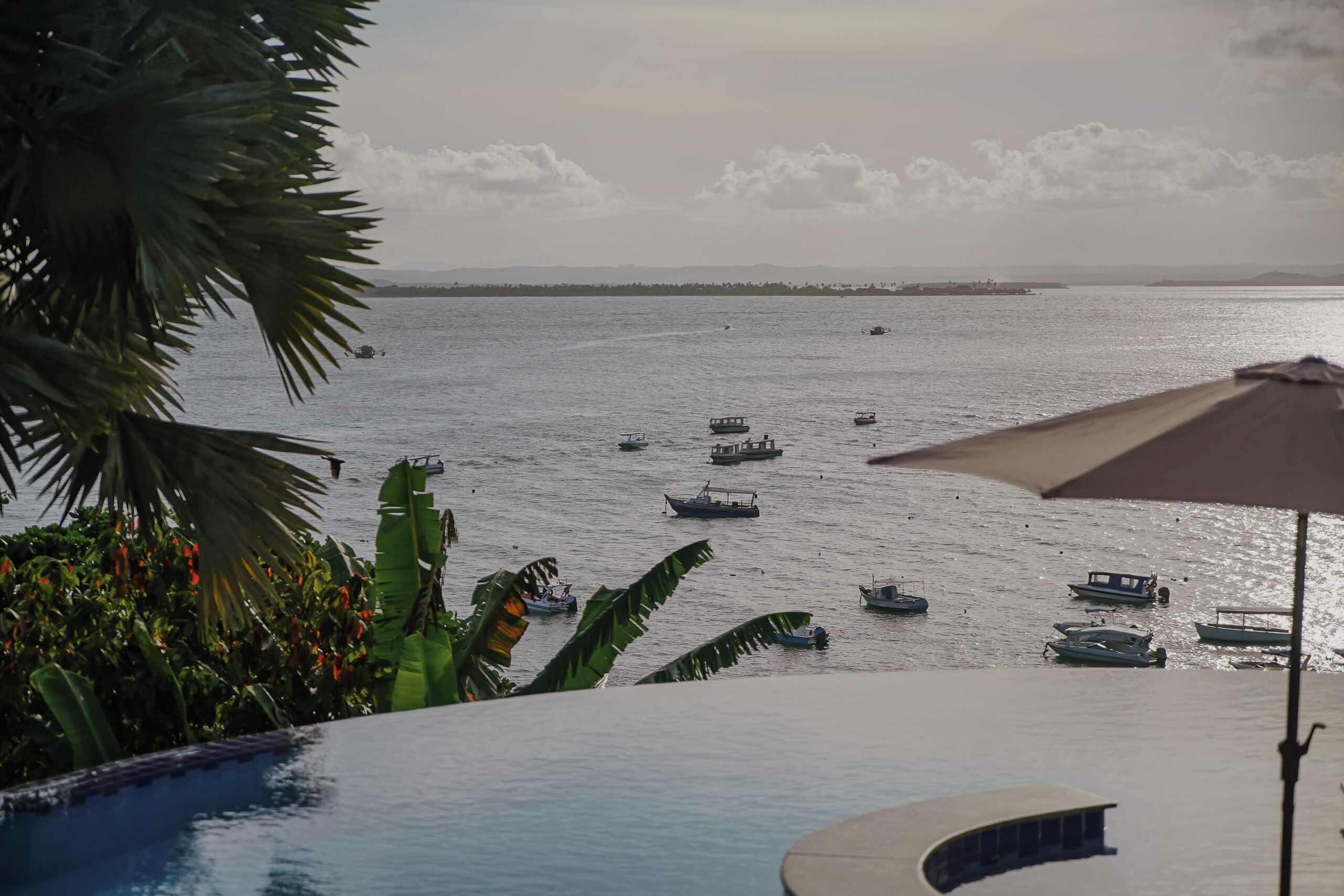 Une vue sur la piscine donnant sur une marina où sont amarrés plusieurs bateaux.