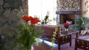 A stone wall, a fireplace, and a wooden bench in a room. - Piedras del Lago (Tandil)