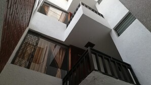 A multi-level residential building with balconies, large windows, and a stairway. - Hotel Venecia Confort (San Juan de Pasto)