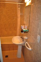 Un baño con bañera, lavamanos y espejo.