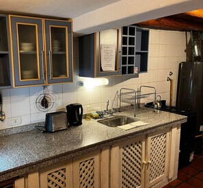 A kitchen with a granite countertop, stainless steel sink, and a toaster. - Hostería La Raclette (San Martin de los Andes)
