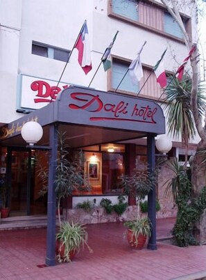 A hotel entrance with a sign reading "Dali hotel" and multiple flags.