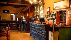 A restaurant interior with a bar area, wooden chairs, and a large mural on the wall. - El Molino - Complejo Turístico (Victoria)