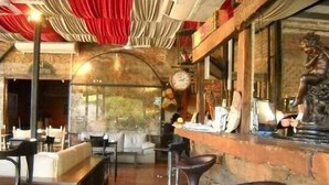 A restaurant interior with a bar area, seating, and a statue. - El Molino - Complejo Turístico (Victoria)