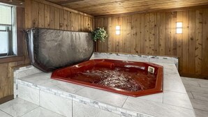 Un área de spa con jacuzzi, paredes de madera y suelo de baldosas.