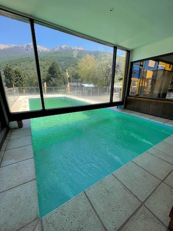 Una piscina al aire libre, sillones reclinables de piscina