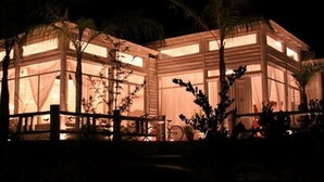 Un grand bâtiment moderne doté de nombreuses pièces, de grandes fenêtres et d’une façade en bois.