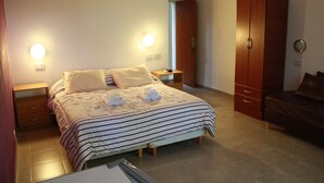 A neatly arranged bedroom with a bed, bedside tables, a wardrobe, and a sofa. - Hotel Sanguinetti (Victoria)