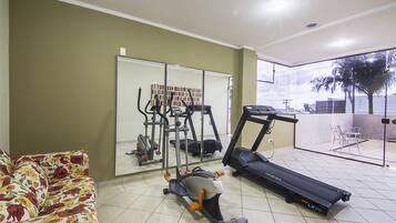 A home gym with exercise equipment, a large mirror, and a view of the outdoors.